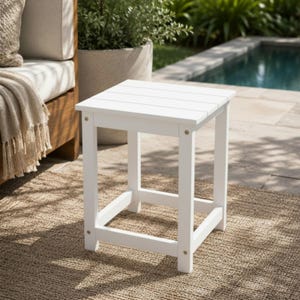 May include: A square side table with a white finish, featuring a slatted tabletop surface and four straight legs connected by lower support rails. The table is constructed with visible metal hardware at each corner joint of the frame.