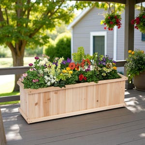 May include: A rectangular wooden planter box filled with a variety of colorful flowers. The flowers include red, yellow, purple, and white blooms. The planter is made of light-colored wood and sits on a wooden deck.
