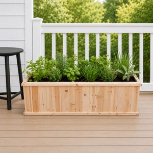 May include: A rectangular wooden planter box with vertical slats, filled with a variety of green herbs including basil, chives, and sage. The planter is positioned on a deck surface next to a black stool, with a white railing in the background.