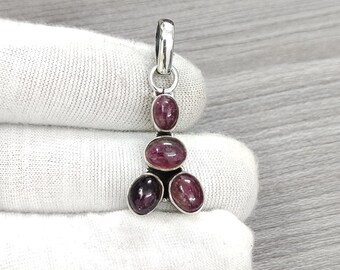 May include: Silver pendant with four pink and purple oval-shaped gemstones. The pendant is in the shape of a teardrop.