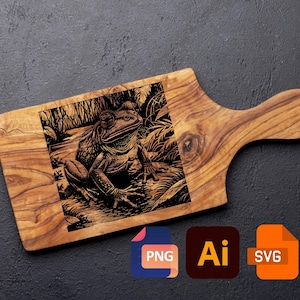 Könnte beinhalten: Holzschneidebrett mit detaillierter Gravur einer Frosch-Illustration in einer natürlichen Umgebung. Das Brett ist hellbraun und hat einen Griff. Enthält PNG-, AI- und SVG-Dateisymbole.