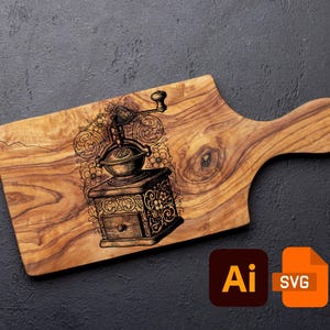May include: A wooden cutting board with a handle, featuring a detailed engraving of a vintage coffee grinder. The grinder is surrounded by floral and scroll designs. The board is made of light brown wood.