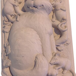May include: A light-colored, rectangular relief sculpture featuring a smiling cat surrounded by three mice. The cat is seated, and the mice are positioned around it, interacting with the cat and the surrounding foliage.