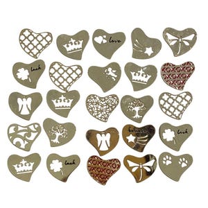 May include: A collection of silver-colored heart-shaped charms with various cut-out designs. Some hearts feature crowns, angels, clovers, and the word "love" or "believe". Other designs include a tree, a dragonfly, and a pattern of "xoxo".
