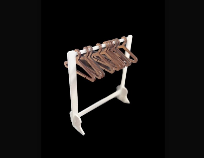 May include: A white wooden clothes rack with a row of brown wooden hangers.