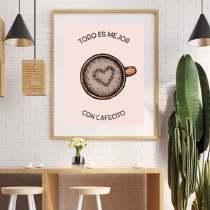 Könnte beinhalten: Ein gerahmter Druck mit rosa Hintergrund und einer Zeichnung einer Kaffeetasse mit einem Herz im Schaum. Der Text "TODO ES MEJOR CON CAFECITO" ist in Schwarz unter der Tasse gedruckt.