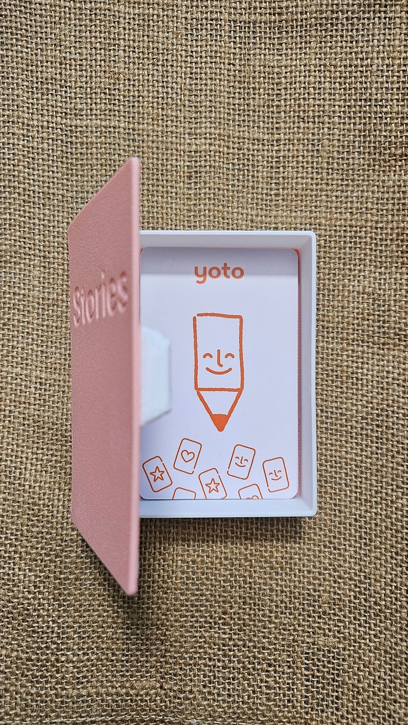 3d printed storage box for holding Yoto cards. Designed to look like a book,this one is Pink with white pages and has the word Stories on the front. This can be fully customised.