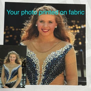 May include: A woman wearing a long-sleeved, sheer, beige top with a blue and white sequined design. The top has a V-neckline and is decorated with rhinestones.