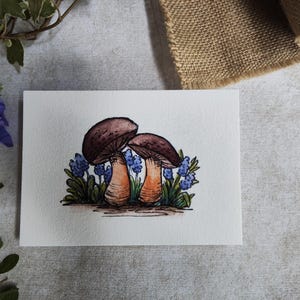 Carte Deux champignons dans les fleurs bleues – Illustration aquarelle