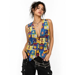 May include: A sleeveless vest featuring a vibrant patchwork pattern with blue, yellow, and purple squares. The design includes illustrations of pumpkins, witches, frogs, and spiderwebs. The vest has a deep V-neckline and a button-down front closure.