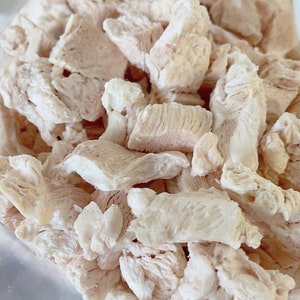 Puede incluir: Primer plano de un mont&oacute;n de pollo desmenuzado, las piezas son blancas y tienen un ligero tono rosado.