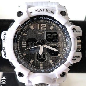 May include: White X Nation digital watch with a black and grey face. The watch features a digital display, analogue hands, and various buttons. The watch has the text "X NATION" on the top and the text "DUAL TIME WR 50M" on the face.
