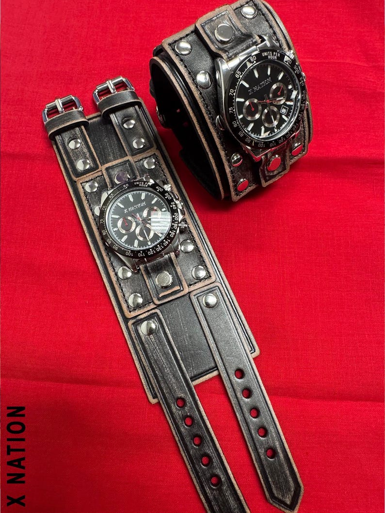 May include: Two black leather wrist cuffs with silver-tone studs and buckles, each featuring a watch with a black face and silver-tone accents. The watches display the text "X NATION".