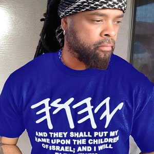 May include: A royal blue t-shirt with white Hebrew text and the quote "AND THEY SHALL PUT MY NAME UPON THE CHILDREN OF ISRAEL; AND I WILL BLESS THEM. NUMBERS 6:27." The person is wearing a black and white head covering.