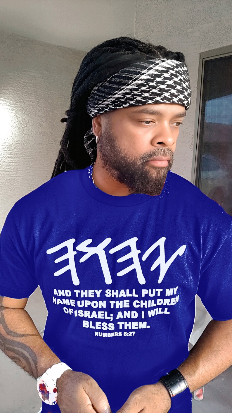May include: A royal blue t-shirt with white Hebrew text and the quote "AND THEY SHALL PUT MY NAME UPON THE CHILDREN OF ISRAEL; AND I WILL BLESS THEM. NUMBERS 6:27." The person is wearing a black and white head covering.