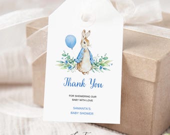 Puede incluir: Una etiqueta de regalo rectangular blanca con una ilustración en acuarela de un conejo marrón con chaqueta azul sosteniendo un globo azul, rodeado de follaje verde. El texto dice Thank You, FOR SHOWERING OUR BABY WITH LOVE, SAMANTA'S BABY SHOWER.