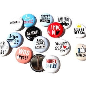Pinback buttons with funny Bavarian sayings and illustrations