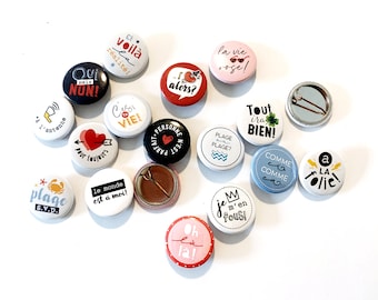 Pinback buttons with funny French sayings and illustrations