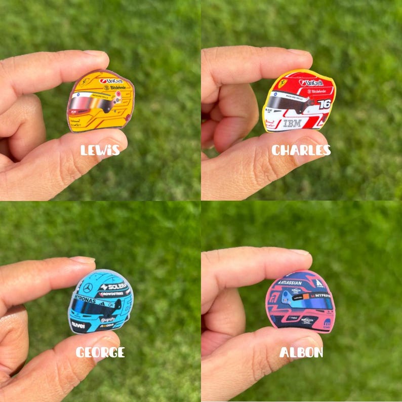 Pode incluir: Quatro pequenos adesivos em formato de capacetes de corrida. Um &eacute; amarelo com o texto LEWIS, um vermelho e branco com o texto CHARLES, um azul claro com o texto GEORGE e um rosa e azul com o texto ALBON, cada um segurado por dedos.
