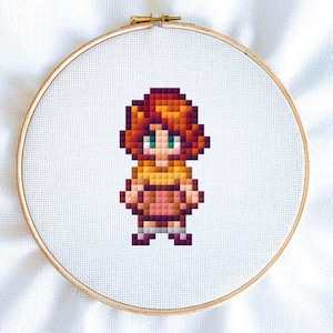 May include: A pixel art cross stitch pattern of a person with red hair, wearing a yellow shirt and a pink skirt.