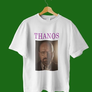 Op de afbeelding: Wit T-shirt met de tekst "THANOS" in paars en een foto van Walter White uit Breaking Bad.