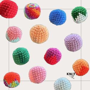 May include: A collection of colorful, crocheted balls in various shades of red, orange, pink, green, blue, and purple. Some balls have a solid color, while others feature a mix of colors. The balls are arranged on a light background.