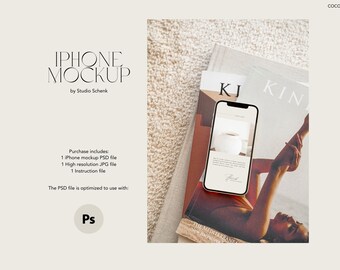 May include: A white iPhone mockup on a magazine with the text "KJ KIN" and a photo of a woman's arm and hand. The phone screen shows a white background with text.