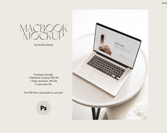 May include: A white laptop computer with a black keyboard and trackpad is open on a white round table. The laptop screen displays a website with the text "SHOP NOW".