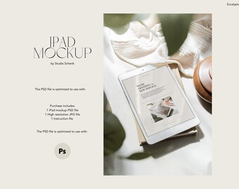 May include: A white iPad mockup with a screen displaying the text "We're offering a new service." The iPad is lying on a stack of books on a white surface with a white cloth and a wooden bowl in the background.