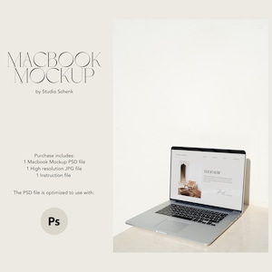 May include: A silver laptop computer with a white screen displaying a website with the text "SHOP NOW". The laptop is on a light brown surface.