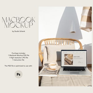 Op de afbeelding: Een witte laptop met een beige en bruine website op het scherm. De laptop staat op een beige kussen met een tijdschrift en een kopje koffie. De laptop staat in een rieten stoel op een terras met een witte muur op de achtergrond.