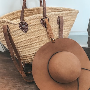 May include: A brown woven tote bag with leather handles and a brown felt hat.