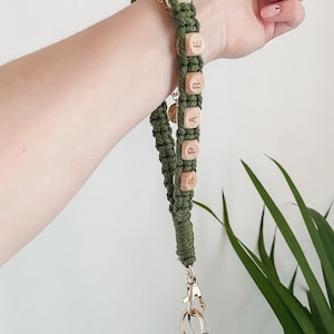 May include: A green and brown key chain with wooden beads that spell out "SPARE KEY". The key chain has a gold metal clasp and a key with a Jeep logo.