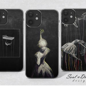 Può includere: Tre custodie per telefono con design diversi. La prima custodia presenta un'illustrazione in bianco e nero di una persona che cade da un edificio. La seconda custodia presenta un'illustrazione in bianco e nero di una donna con un vestito con le braccia alzate. La terza custodia presenta un'illustrazione in bianco e nero di una donna con un vestito bianco con delle corde attaccate a lei, che assomiglia a una marionetta. Il testo "Soul + Dream design" è stampato sul fondo della terza custodia.