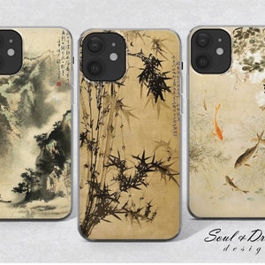 Pode incluir: Três capas para iPhone com designs diferentes. A primeira capa tem uma paisagem em estilo aquarela com montanhas e árvores. A segunda capa tem um design de bambu com tinta preta e branca. A terceira capa tem um design em estilo aquarela com peixes e flores.