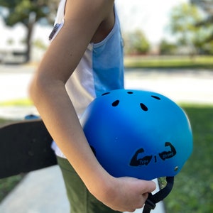 May include: A blue helmet with black stickers that say "Type 1 Strong" on the side. The helmet is being held by a person.