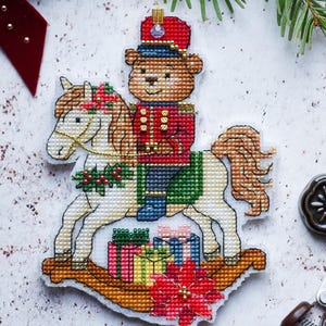 Mascarada en el bosque. Patrón de punto de cruz del Cascanueces (PDF), adorno navideño, versiones con cuentas y regular. Diseño de oso a caballo.