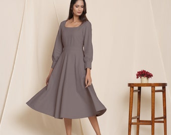 May include: A gray midi dress with a square neckline and long sleeves. The dress has a fitted bodice and a flowing skirt.