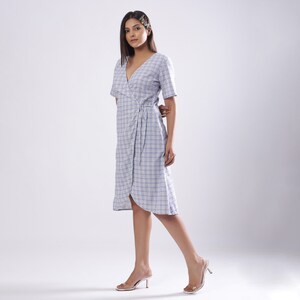 May include: A blue and white plaid wrap dress with short sleeves and a tie at the waist.