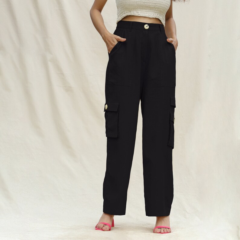 May include: Black cargo pants with multiple pockets and a gold button closure.