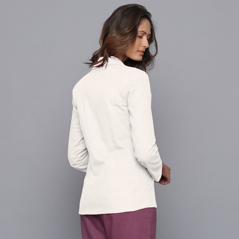 May include: A white long-sleeved shirt with a collar. The shirt is fitted and has a slightly longer length at the back.