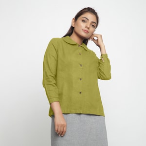 May include: A green collared shirt with long sleeves and a button-up front.