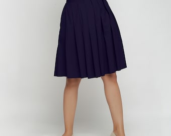 May include: A navy blue pleated skirt with a knee-length hemline.