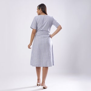 May include: A blue and white plaid dress with a short sleeve and a knee-length skirt.
