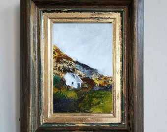 May include: A framed painting of a white house on a green hillside with a cloudy sky in the background.