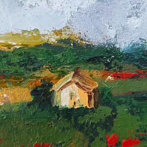 Op de afbeelding: Een schilderij van een klein huis in een veld met rode bloemen op de voorgrond. De lucht is bewolkt en het huis is geschilderd in tinten geel en bruin.