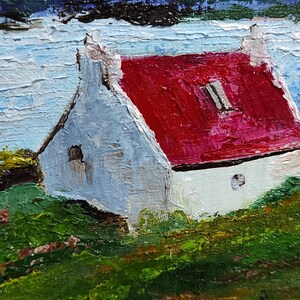 May include: A painting of a white cottage with a red roof, set against a backdrop of a blue mountain range and a body of water. The cottage has a small window and a round opening in the wall. The scene is painted in a loose, impressionistic style.