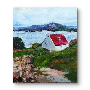 May include: A painting of a white cottage with a red roof, set against a backdrop of a blue body of water and green hills. The cottage is situated on a grassy hillside, with a path leading up to it.