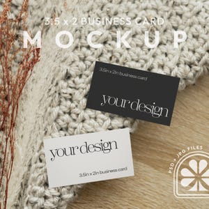 May include: Two 3.5 x 2 inch business cards, one white and one black, with the text "your design" on each. The cards are lying on a white crocheted surface and a wooden surface.