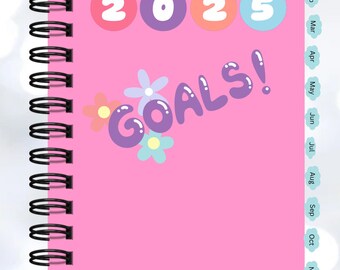 Może przedstawiać: Różowy notes w spirali z tekstem "2025 GOALS!" w kolorowych literach i kwiatach. Notes ma miesięczny kalendarz po prawej stronie.